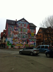 A building with graffiti that is against calling illegal immigration illegal.